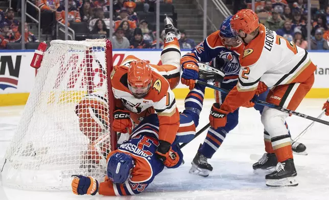 Anaheim Ducks' Radko Gudas (7) checks Edmonton Oilers' Viktor Arvidsson (33) as Vasily Podkolzin (92) and Jackson LaCombe (2) battle in front of the net during the second period of an NHL hockey game in Edmonton, Alberta, Friday, Jan. 3, 2025. (Jason Franson/The Canadian Press via AP)