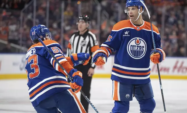 Edmonton Oilers' Viktor Arvidsson (33) and Darnell Nurse (25) celebrate after a goal against the Anaheim Ducks during second-period NHL hockey game action in Edmonton, Alberta, Friday, Jan. 3, 2025. (Jason Franson/The Canadian Press via AP)