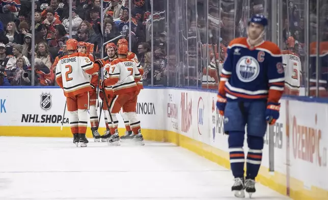 Anaheim Ducks celebrate a goal as Edmonton Oilers' Connor McDavid (97) skates past during the second period of an NHL hockey game, Friday, Jan. 3, 2025 in Edmonton, Alberta. (Jason Franson/The Canadian Press via AP)