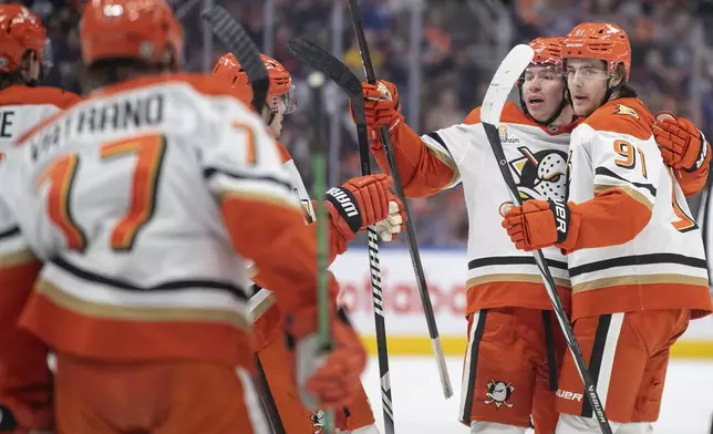 Anaheim Ducks' Leo Carlsson (91) and Jackson LaCombe, second from right, celebrate after a goal against the Edmonton Oilers during third-period NHL hockey game action in Edmonton, Alberta, Friday, Jan. 3, 2025. (Jason Franson/The Canadian Press via AP)