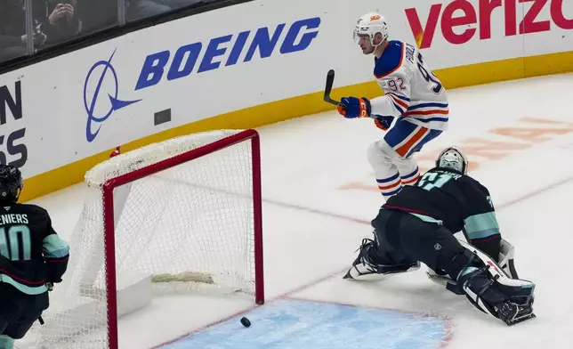 Edmonton Oilers right wing Vasily Podkolzin (92) scores against Seattle Kraken goaltender Philipp Grubauer, right, during the first period of an NHL hockey game Saturday, Jan. 4, 2025, in Seattle. (AP Photo/Lindsey Wasson)