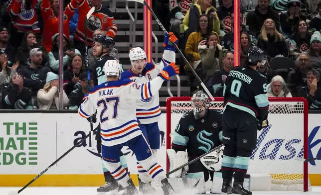 Edmonton Oilers center Ryan Nugent-Hopkins (93) celebrates after his goal with teammate Brett Kulak (27) as Seattle Kraken defenseman Jamie Oleksiak, left, goaltender Philipp Grubauer, second from right, and center Chandler Stephenson (9) look on during the second period of an NHL hockey game Saturday, Jan. 4, 2025, in Seattle. (AP Photo/Lindsey Wasson)