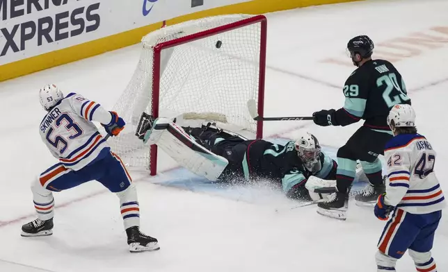 Edmonton Oilers center Jeff Skinner (53) scores against Seattle Kraken goaltender Philipp Grubauer, center, as Kraken defenseman Vince Dunn (29) looks on during the first period of an NHL hockey game Saturday, Jan. 4, 2025, in Seattle. (AP Photo/Lindsey Wasson)