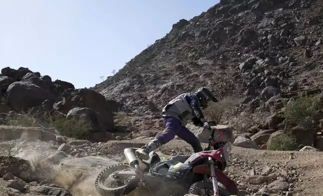 Rider Jordan Strachan falls as he competes during stage one of the Dakar Rally with start and finish in Bisha, Saudi Arabia, Saturday, Jan. 4, 2025. (AP Photo/Christophe Ena)