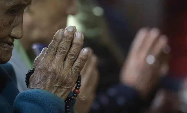 A Tibetan woman offers a prayer in the remembrance of those who lost their lives in the recent earthquake, at a Tibetan camp in Lalitpur, Nepal, on Wednesday, Jan. 8, 2025. (AP Photo/Niranjan Shrestha)