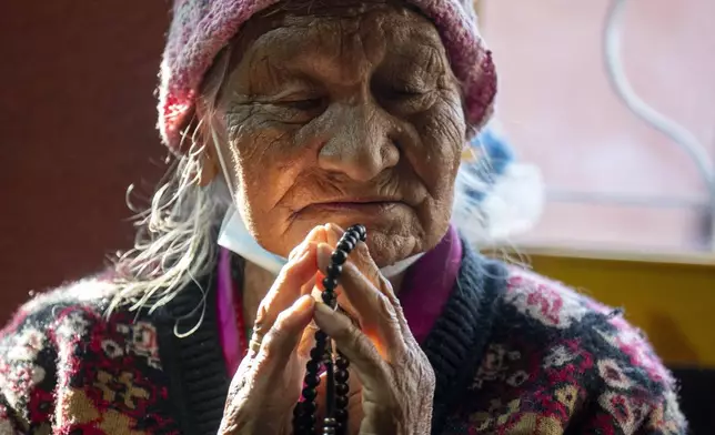 A Tibetan woman offers a prayer in the remembrance of those who lost their lives in the recent earthquake, at a Tibetan camp in Lalitpur, Nepal, on Wednesday, Jan. 8, 2025. (AP Photo/Niranjan Shrestha)