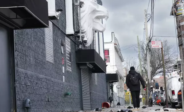 Members of the media work in front of the nightclub Amazura, left, in the Queens borough of New York, Thursday, Jan. 2, 2025. (AP Photo/Seth Wenig)