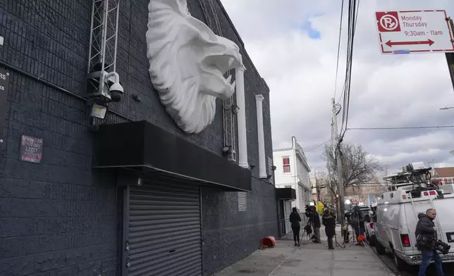 Members of the media work in front of the nightclub Amazura, left, in the Queens borough of New York, Thursday, Jan. 2, 2025. (AP Photo/Seth Wenig)