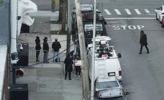 Members of the media work in front of the nightclub Amazura, left, in the Queens borough of New York, Thursday, Jan. 2, 2025. (AP Photo/Seth Wenig)