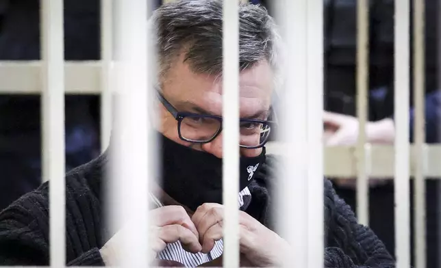 FILE - Viktar Babaryka, a former presidential hopeful, makes a heart gesture while sitting in a defendants’ cage during his trial in Minsk, Belarus, on Feb. 17, 2021. (Oksana Manchuk/BelTA Pool Photo via AP)