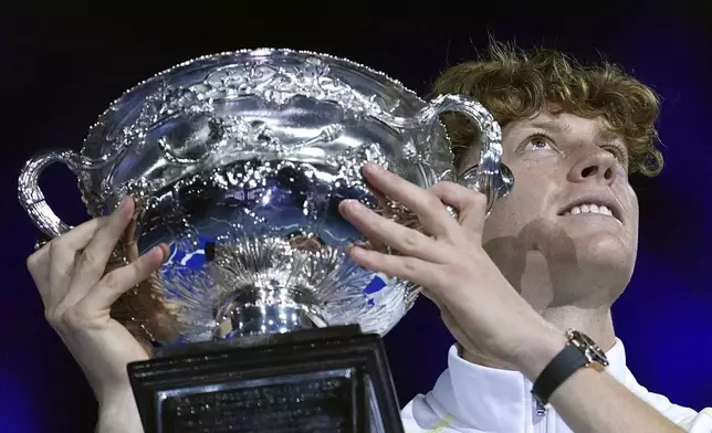 Jannik Sinner of Italy holds the Norman Brookes Challenge Cup aloft after defeating Alexander Zverev of Germany in the men's singles final at the Australian Open tennis championship in Melbourne, Australia, Sunday, Jan. 26, 2025. (AP Photo/Ng Han Guan)