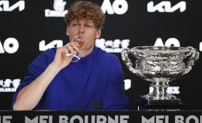 Jannik Sinner of Italy drinks a glass champagne during a press conference after defeating Alexander Zverev of Germany in the men's singles final at the Australian Open tennis championship in Melbourne, Australia, Monday, Jan. 27, 2025. (AP Photo/Manish Swarup)