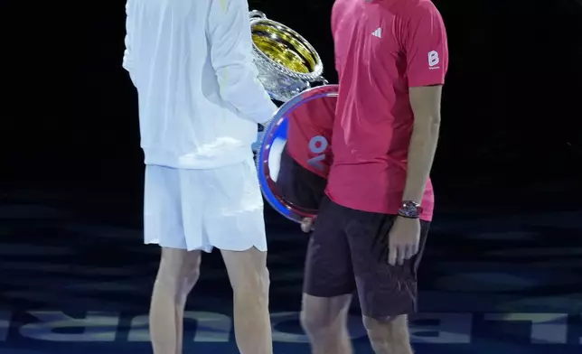 Alexander Zverev of Germany, right, turns to leave the stage after he congratulated Jannik Sinner of Italy following the men's singles final at the Australian Open tennis championship in Melbourne, Australia, Sunday, Jan. 26, 2025. (AP Photo/Vincent Thian)