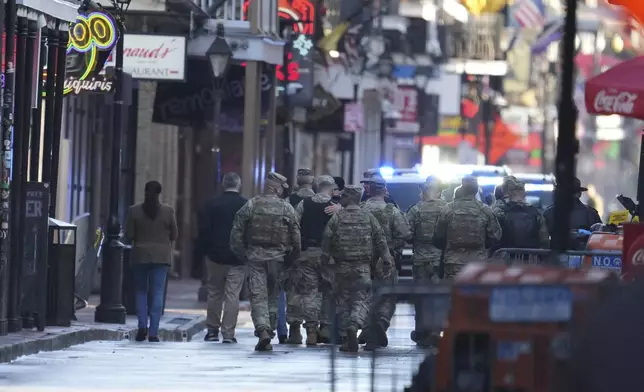 Military personnel walk down Bourbon street, Thursday, Jan. 2, 2025 in New Orleans. (AP Photo/George Walker IV)