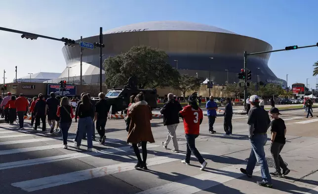 Fans walk towards the Caesars Superdome ahead of the Sugar Bowl NCAA College Football Playoff game, Thursday, Jan. 2, 2025, in New Orleans. (AP Photo/Butch Dill)