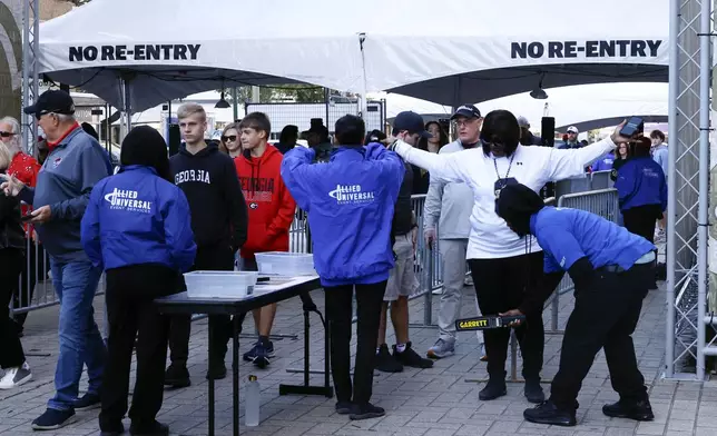 Fans pass through security check points as they enter the Caesars Superdome fan zone ahead of the Sugar Bowl NCAA College Football Playoff game, Thursday, Jan. 2, 2025, in New Orleans. (AP Photo/Butch Dill)