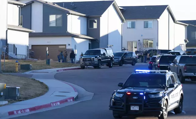 Investigators stand outside a townhouse complex in northeastern Colorado Springs, Colo., Thursday, Jan. 2, 2025, as the investigation connected to the explosion of a Tesla Cybertruck outside President-elect Donald Trump's Las Vegas hotel continues. (Christian Murdock/The Gazette via AP)