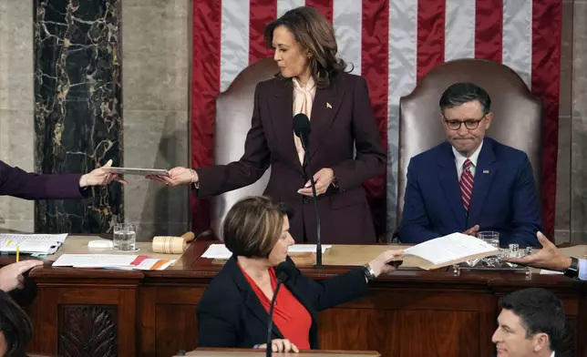 Vice President Kamala Harris is handed a certification as House Speaker Mike Johnson of La., watches while teller Sen. Amy Klobuchar, D-Minn., stands at the clerk's podium as a joint session of Congress convenes to confirm the Electoral College votes, affirming President-elect Donald Trump's victory in the presidential election, Monday, Jan. 6, 2025, at the U.S. Capitol in Washington. (AP Photo/Matt Rourke)