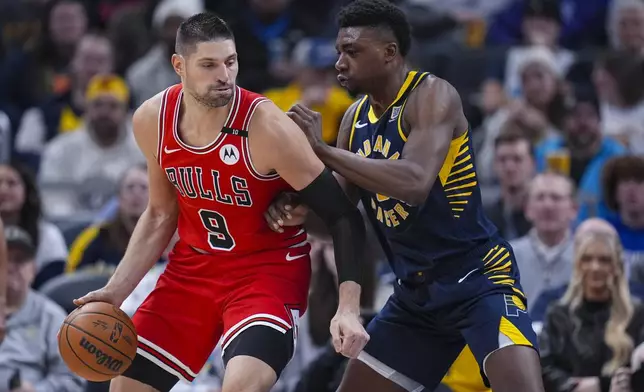 Chicago Bulls center Nikola Vucevic (9) drives against Indiana Pacers center Thomas Bryant (3) during the first half of an NBA basketball game in Indianapolis, Wednesday, Jan. 8, 2025. (AP Photo/Michael Conroy)