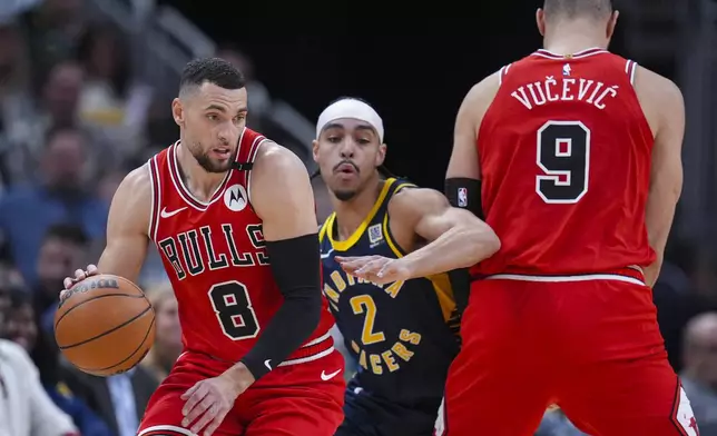 Indiana Pacers guard Andrew Nembhard (2) fights through the screen from Chicago Bulls center Nikola Vucevic (9) and he defends guard Zach LaVine (8) during the first half of an NBA basketball game in Indianapolis, Wednesday, Jan. 8, 2025. (AP Photo/Michael Conroy)