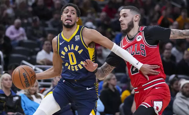 Indiana Pacers guard Tyrese Haliburton (0) holds off Chicago Bulls guard Lonzo Ball (2). As he drives to the basket during the first half of an NBA basketball game in Indianapolis, Wednesday, Jan. 8, 2025. (AP Photo/Michael Conroy)