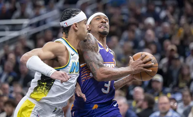 Phoenix Suns guard Bradley Beal (3) drives the ball toward the basket while defended by Indiana Pacers guard Andrew Nembhard, left, during the first half of an NBA basketball game in Indianapolis, Saturday, Jan. 4, 2025. (AP Photo/Doug McSchooler)