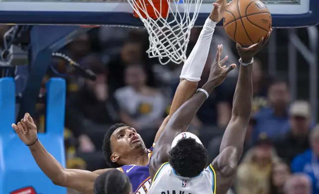 Phoenix Suns forward Ryan Dunn, top left, defends against Indiana Pacers forward Pascal Siakam (43) who shoots during the first half of an NBA basketball game in Indianapolis, Saturday, Jan. 4, 2025. (AP Photo/Doug McSchooler)