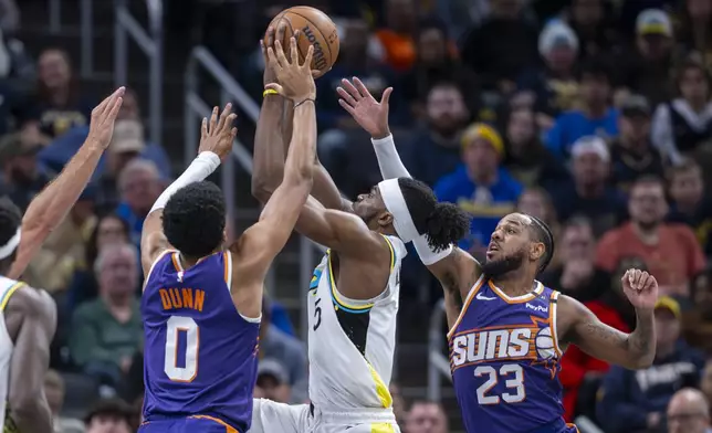 Phoenix Suns forward Ryan Dunn (0) and guard Monte Morris (23), right, attempt to block a shot by Indiana Pacers forward Jarace Walker (5) during the first half of an NBA basketball game in Indianapolis, Saturday, Jan. 4, 2025. (AP Photo/Doug McSchooler)