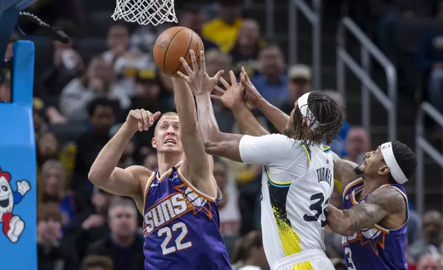 Phoenix Suns center Mason Plumlee (22) reaches for a rebound against Indiana Pacers center Myles Turner (33) during the first half of an NBA basketball game in Indianapolis, Saturday, Jan. 4, 2025. (AP Photo/Doug McSchooler)