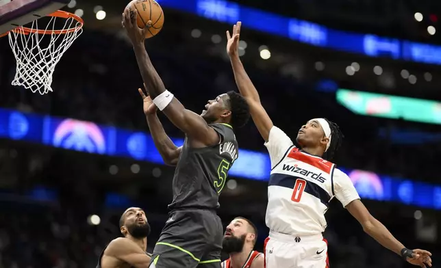 Minnesota Timberwolves guard Anthony Edwards (5) goes to the basket past Washington Wizards guard Bilal Coulibaly (0) during the first half of an NBA basketball game, Monday, Jan. 13, 2025, in Washington. (AP Photo/Nick Wass)