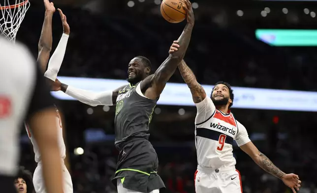 Minnesota Timberwolves forward Julius Randle, left, goes to the basket as he is fouled by Washington Wizards forward Justin Champagnie (9) during the first half of an NBA basketball game, Monday, Jan. 13, 2025, in Washington. (AP Photo/Nick Wass)
