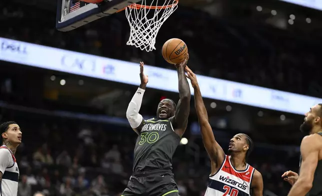 Minnesota Timberwolves forward Julius Randle (30) goes to the basket as he is fouled by Washington Wizards forward Alex Sarr (20) during the first half of an NBA basketball game, Monday, Jan. 13, 2025, in Washington. (AP Photo/Nick Wass)