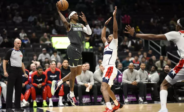 Minnesota Timberwolves forward Jaden McDaniels (3) looks to pass the ball against Washington Wizards guard Bub Carrington, center right, during the first half of an NBA basketball game, Monday, Jan. 13, 2025, in Washington. (AP Photo/Nick Wass)