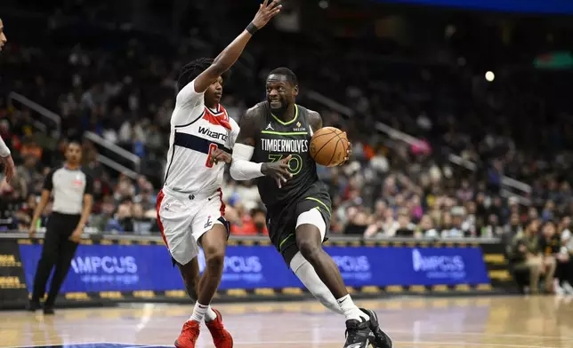 Minnesota Timberwolves forward Julius Randle (30) drives against Washington Wizards guard Bub Carrington (8) during the first half of an NBA basketball game, Monday, Jan. 13, 2025, in Washington. (AP Photo/Nick Wass)