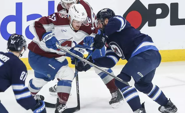Winnipeg Jets' Dylan DeMelo (right) defends against Colorado Avalanche's Casey Mittelstadt (37) and Joel Kiviranta (94) during first period NHL action in Winnipeg on Saturday, January 11, 2025. (John Woods/The Canadian Press via AP)