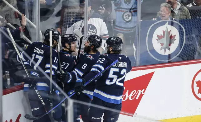 Winnipeg Jets' Adam Lowry (17), Nikolaj Ehlers (27), Alex Iafallo (9) and Dylan Coghlan (52) celebrate Ehlers' goal against the Colorado Avalanche during first period NHL action in Winnipeg on Saturday, January 11, 2025. (John Woods/The Canadian Press via AP)