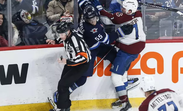 Winnipeg Jets' Mark Scheifele (55) and Colorado Avalanche's Devon Toews (7) collide during second period NHL action in Winnipeg on Saturday, January 11, 2025. (John Woods/The Canadian Press via AP)