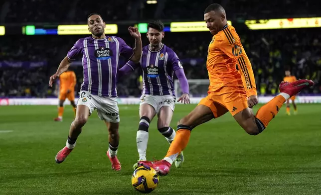Real Madrid's Kylian Mbappe, right, duels for the balls with Valladolid's Luis Perez, center, and Valladolid's Anuar, left, during the Spanish La Liga soccer match between Valladolid and Real Madrid at the Jose Zorrilla stadium in Valladolid, Spain, Saturday, Jan. 25, 2025. (AP Photo/Manu Fernandez)