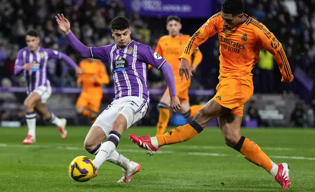 Real Madrid's Jude Bellingham, right, tries a shot during the Spanish La Liga soccer match between Valladolid and Real Madrid at the Jose Zorrilla stadium in Valladolid, Spain, Saturday, Jan. 25, 2025. (AP Photo/Manu Fernandez)