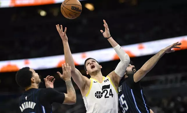 Utah Jazz center Walker Kessler (24) battles for a rebound between Orlando Magic guard Cole Anthony, left, and center Goga Bitadze (35) during the first half of an NBA basketball game, Sunday, Jan. 5, 2025, in Orlando, Fla. (AP Photo/Phelan M. Ebenhack)