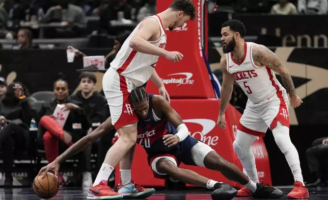 Washington Wizards forward Alex Sarr (20) reaches for the ball as Houston Rockets center Alperen Sengun (28) and guard Fred VanVleet (5) defend during the first half of an NBA basketball game Tuesday, Jan. 7, 2025, in Washington. (AP Photo/Jess Rapfogel)