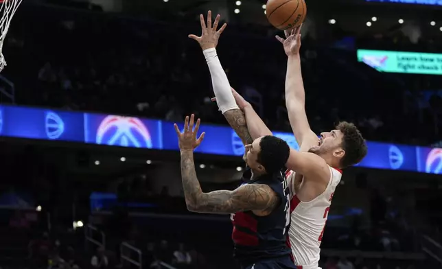 Houston Rockets center Alperen Sengun (28) goes up against Washington Wizards forward Kyle Kuzma (33) during the first half of an NBA basketball game Tuesday, Jan. 7, 2025, in Washington. (AP Photo/Jess Rapfogel)