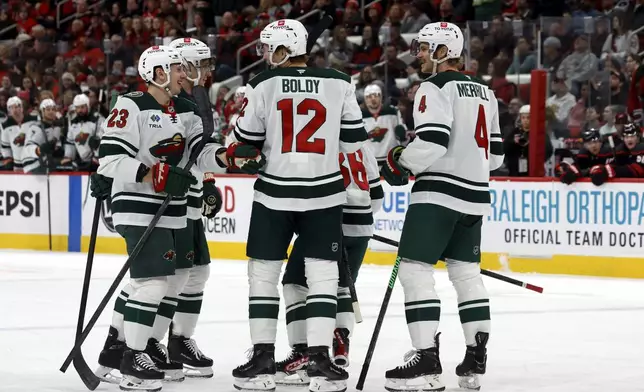 Minnesota Wild players celebrate after a goal against the Carolina Hurricanes during the first period of an NHL hockey game in Raleigh, N.C., Saturday, Jan. 4, 2025. (AP Photo/Karl DeBlaker)