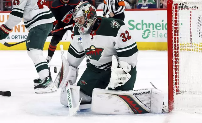 Minnesota Wild goaltender Filip Gustavsson (32) blocks a shot of the Carolina Hurricanes during the second period of an NHL hockey game in Raleigh, N.C., Saturday, Jan. 4, 2025. (AP Photo/Karl DeBlaker)