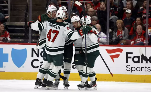 The Minnesota Wild celebrate a goal during the second period of an NHL hockey game against the Carolina Hurricanes in Raleigh, N.C., Saturday, Jan. 4, 2025. (AP Photo/Karl DeBlaker)