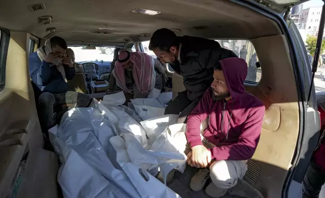 Mourners transport the bodies of their relatives killed in the Israeli bombardment of the Gaza Strip, during their funeral in Deir al-Balah, Wednesday, Jan. 8, 2025. (AP Photo/Abdel Kareem Hana)