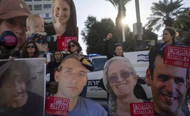 Relatives and supporters of Israeli hostages held by Hamas in Gaza hold photos of their loved ones during a protest calling for their return, in Tel Aviv, Israel, Wednesday, Jan. 8, 2025. (AP Photo/Ohad Zwigenberg)