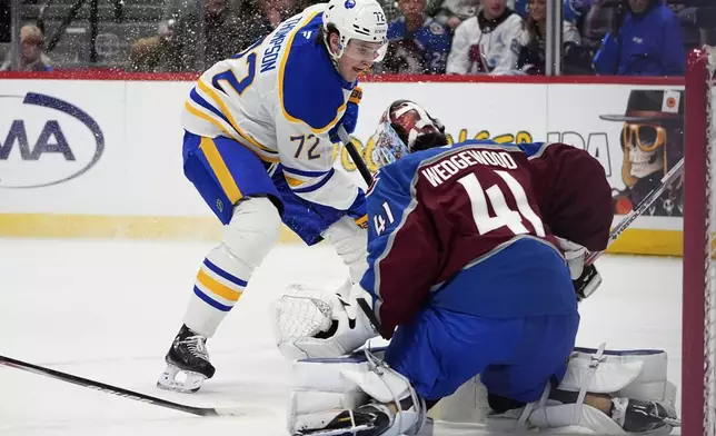 Buffalo Sabres center Tage Thompson, back, puts a shot on Colorado Avalanche goaltender Scott Wedgewood in the second period of an NHL hockey game Thursday, Jan. 2, 2025, in Denver. (AP Photo/David Zalubowski)