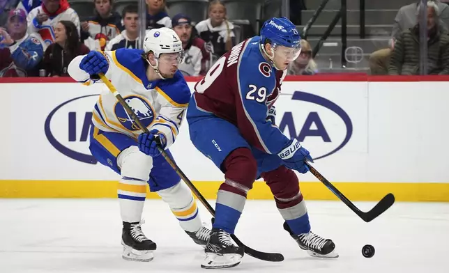 Colorado Avalanche center Nathan MacKinnon, right, drives past Buffalo Sabres defenseman Bowen Byram in the first period of an NHL hockey game Thursday, Jan. 2, 2025, in Denver. (AP Photo/David Zalubowski)