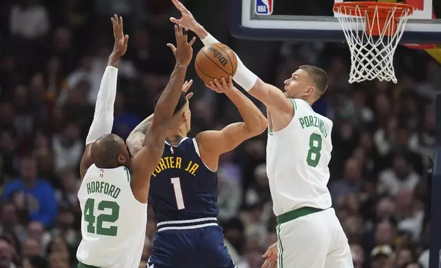 Denver Nuggets forward Michael Porter Jr., center, goes up for a shot as Boston Celtics centers Al Horford, left, and Kristaps Porzingis defend in the first half of an NBA basketball game Tuesday, Jan. 7, 2025, in Denver. (AP Photo/David Zalubowski)